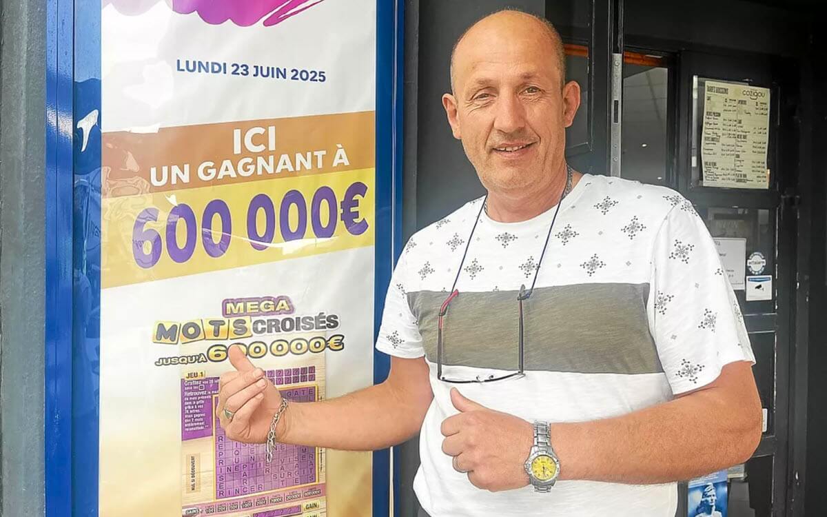 Pascal Croguennec, le gérant de l'Effet Mer devant l'affiche du Mega Mos Croisés FDJ